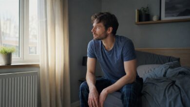 Nachdenklicher Mann am Morgen am Bettrand mit Tageslicht als Symbol für ein Morgentief